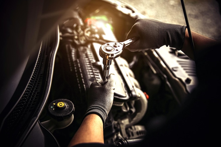 Photo un mécanicien tient la clé pour réparer un problème de moteur de voiture.