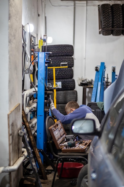 Un mécanicien travaille sur un pneu dans un magasin de voitures.