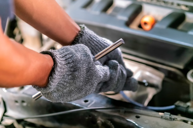 Mécanicien utilisant une clé et un tournevis pour travailler