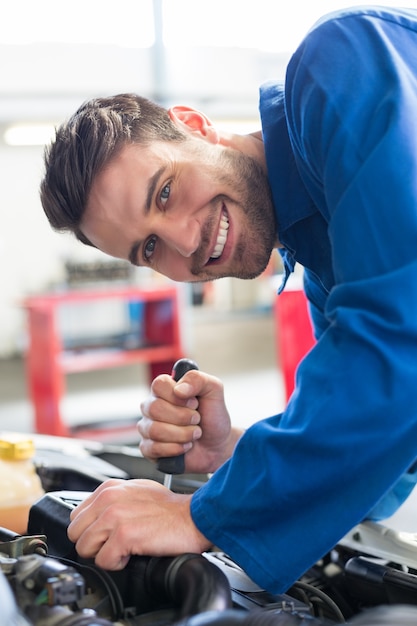 Mécanicien utilisant un tournevis sur le moteur