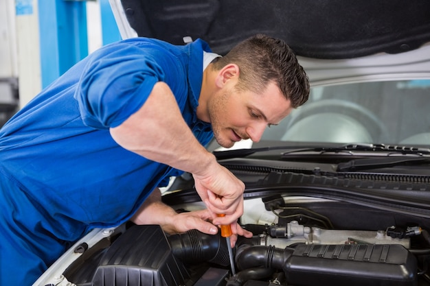 Mécanicien utilisant un tournevis sur le moteur