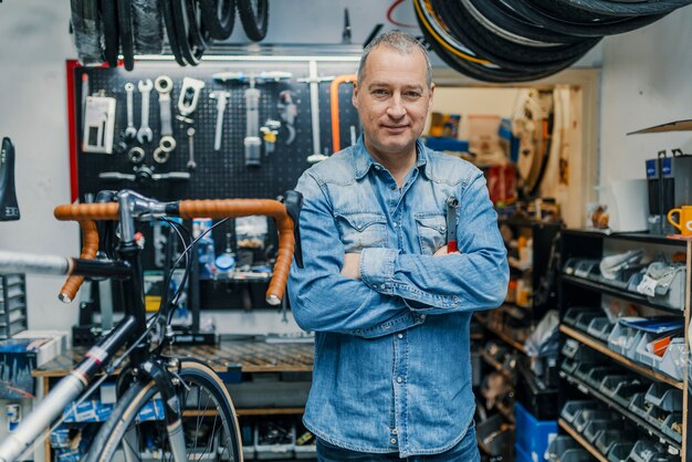 Mécanicien De Vélo élégant Debout Dans Son Atelier.