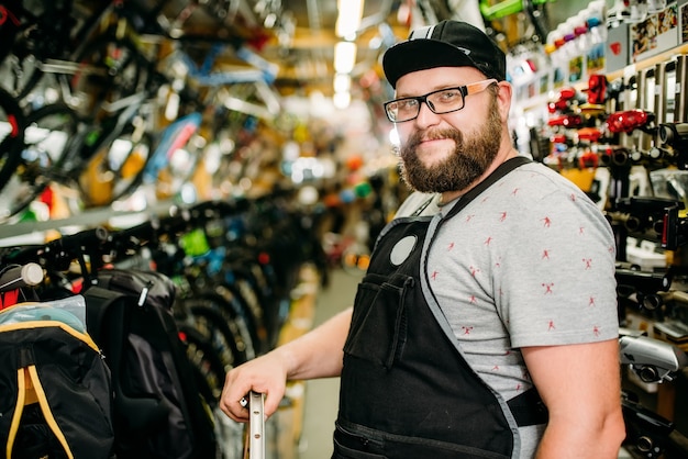 Mécanicien de vélo professionnel avec roue dans un magasin de vélo. Magasin de sport cycliste.