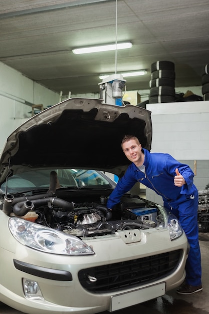 Mécanicien en voiture donnant le pouce en l&#39;air geste