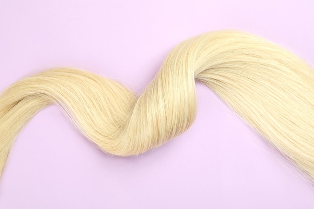 Une mèche de cheveux blonds sur fond violet