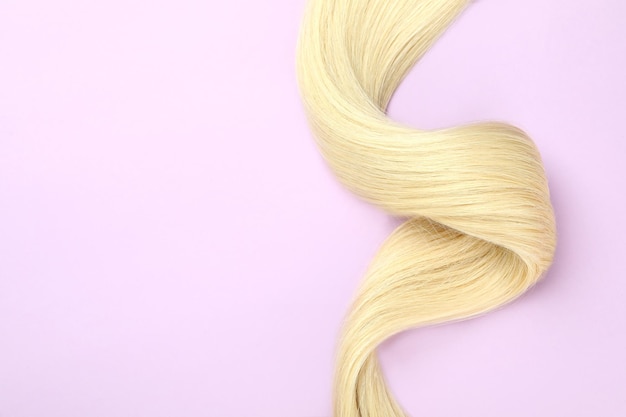 Une mèche de cheveux blonds sur fond violet