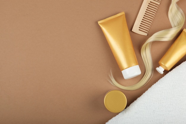 Une mèche de produits de soins capillaires pour cheveux blonds et un peigne sur fond coloré