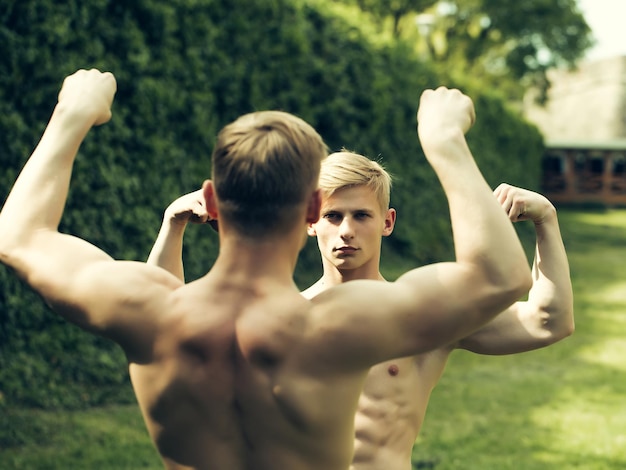 Mecs musclés posant en plein air