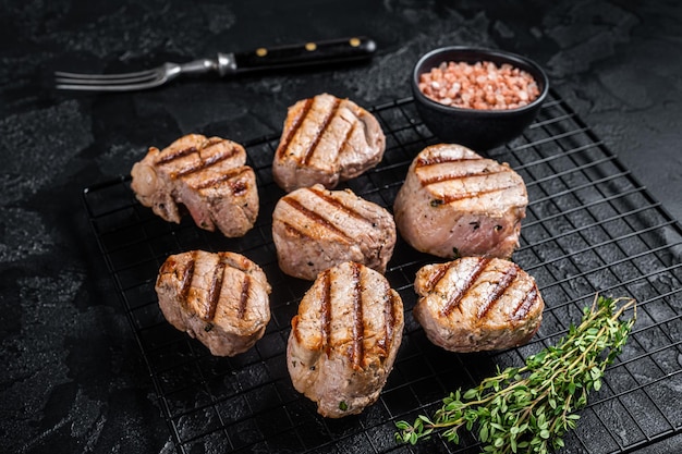 Médaillons de porc grillés steaks de viande de filet sur une grille Fond noir Vue de dessus