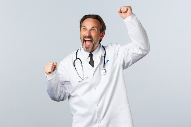 Photo médecin adulte avec stéthoscope en uniforme étant heureux