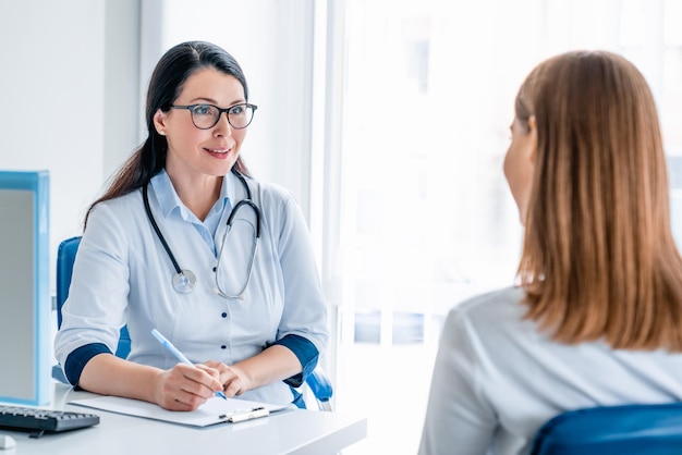 Médecin adulte travaillant et écoutant le patient dans une clinique moderne