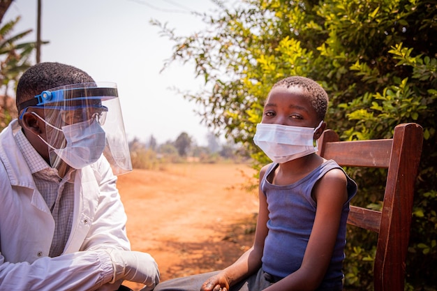 Un médecin africain parle à un enfant patient lors d'un examen médical Concept de soins de santé en Afrique