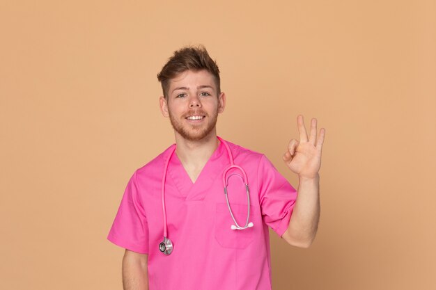 Médecin africain portant un uniforme rose sur fond jaune