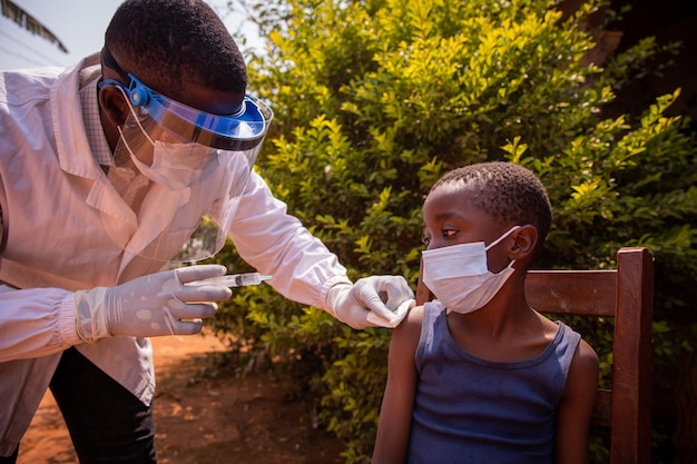 Un médecin en Afrique vaccine un enfant Un médecin injecte le vaccin contre le coronavirus à un enfant en Afrique