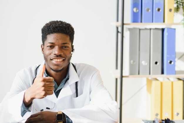 Médecin afro-américain amical dans un bureau moderne