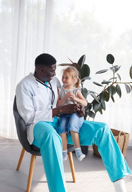 Un médecin afro-américain communique avec une petite patiente