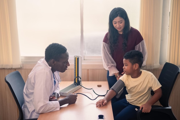 Médecin afro-américain examinant un enfant noir avec stéthoscope