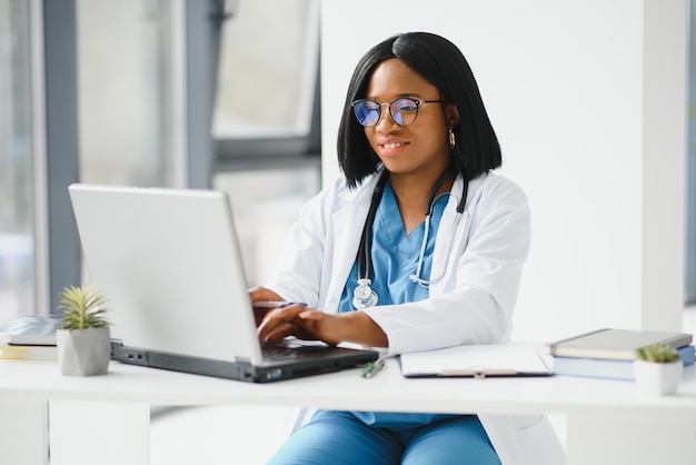 Médecin afro-américain travaillant dans son bureau à la clinique