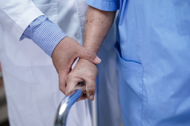 Médecin aide un patient asiatique senior woman walk with walker at hospital