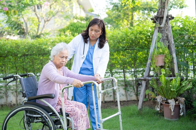 Médecin aide et soins Asiatique senior ou âgée vieille dame patiente assise sur un fauteuil roulant au parc dans l'hôpital de soins infirmiers sain concept médical fort