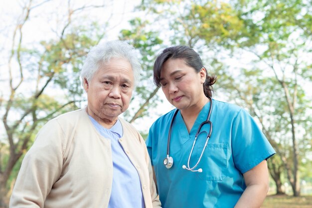 Médecin Aide Et Soins Femme Senior Asiatique En Marchant Au Parc.