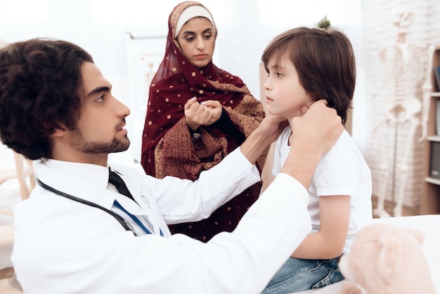 Un médecin arabe diagnostique un petit garçon.