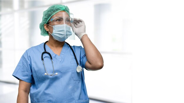 Médecin asiatique portant un écran facial et une combinaison d'EPI nouvelle norme pour vérifier que le patient protège l'infection de sécurité Covid19 Épidémie de coronavirus dans le service hospitalier de soins infirmiers en quarantaine