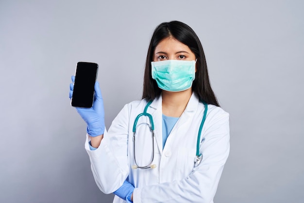 Médecin asiatique tenant un téléphone portable