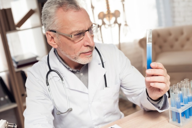 Médecin assis au bureau avec microscope et stéthoscope.