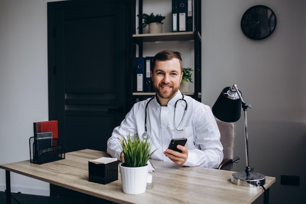 Médecin assis à table dans la salle de consultation