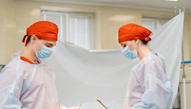 Médecin avec assistance travaillant ensemble. Couple de jeunes chirurgiens travaillant dans un hôpital moderne.