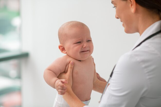 Médecin attentif examinant un patient pédiatrique effrayé