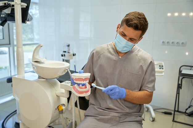 Médecin attentionné démontrant la bonne façon de se brosser les dents