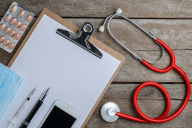 Photo médecin au travail avec un stéthoscope sur une table en bois