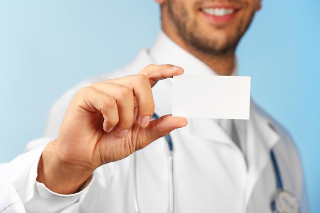 Photo médecin avec badge vierge sur fond bleu