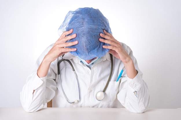 Un médecin avec un bonnet bleu sur la tête médecin fatigué