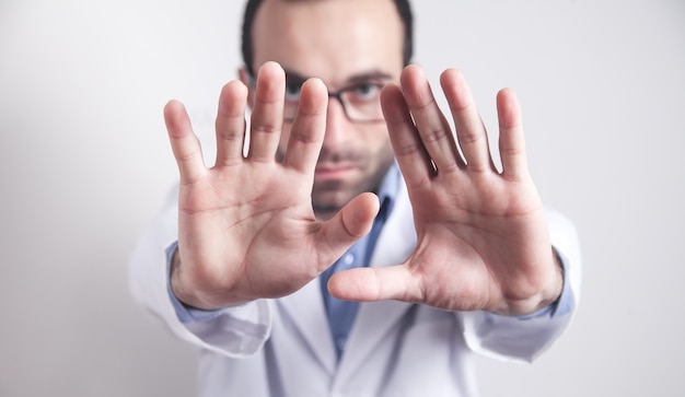 Médecin caucasien montrant un panneau d'arrêt.