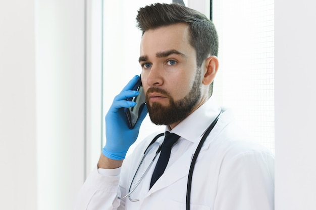 Médecin-chef confiant parlant par téléphone à l'hôpital