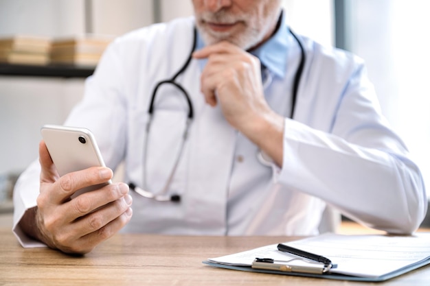 un médecin cherche les dossiers médicaux des patients dans son smartphone