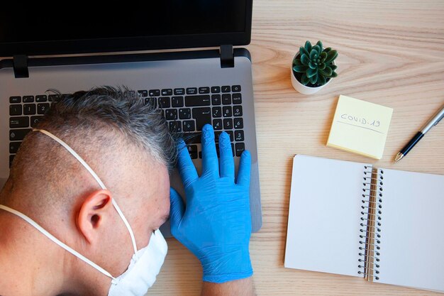 Médecin Chercheur Endormi Sur Le Bureau Sur Ordinateur Portable Mains Masculines Dans Des Gants De Protection Bleus Fatigué Surmené à La Clinique Continuez à Vous Battre Dans Le Concept Médical Et De Santé