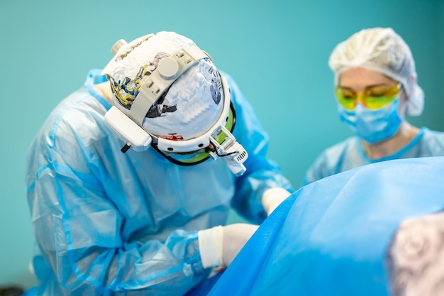 Photo médecin chirurgical concentré et infirmière opérant un patient