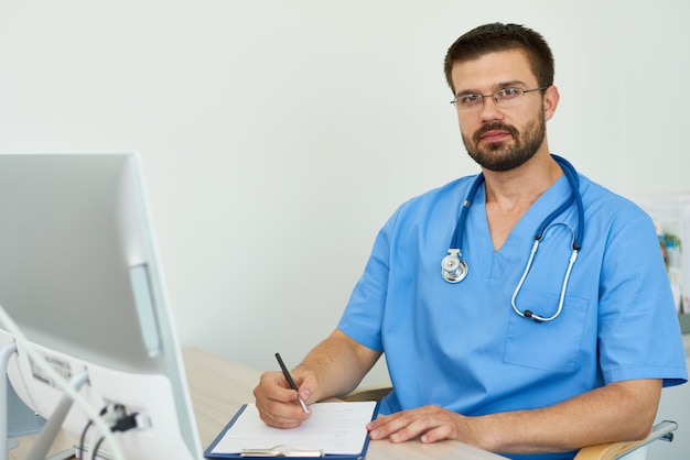 Médecin confiant posant au bureau