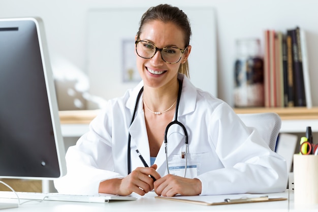 Photo médecin confiante au bureau en regardant la caméra.