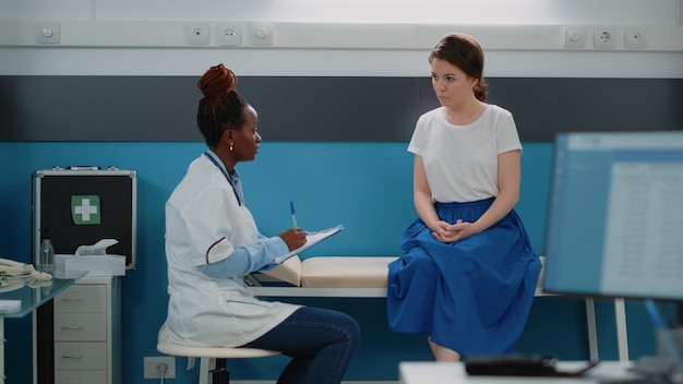 Médecin consultant le patient et prenant des notes pour le diagnostic