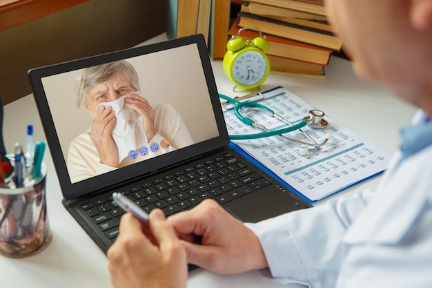 Le médecin consulte une femme âgée malade. Travaillez en ligne.