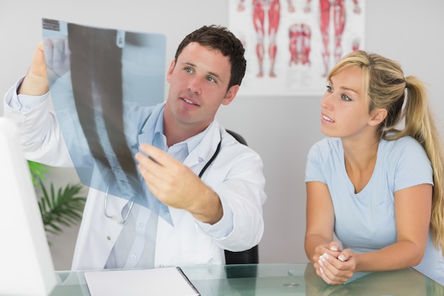 Médecin de contenu montrant un patient quelque chose sur xray