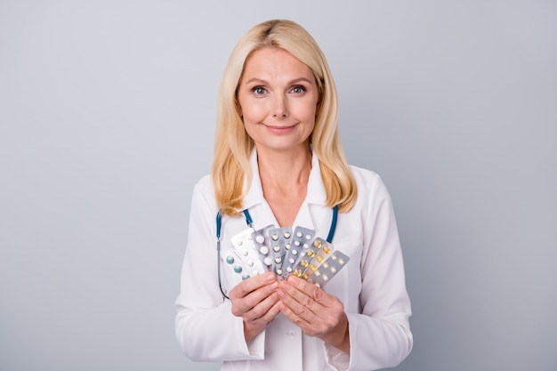 médecin en costume blanc avec stéthoscope détient des pilules