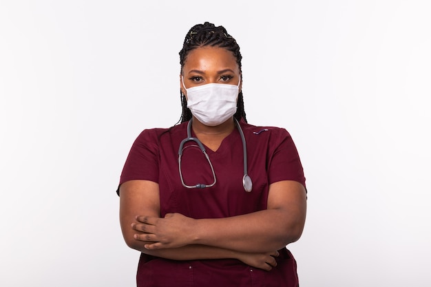 Photo médecin dans un masque médical sur mur blanc