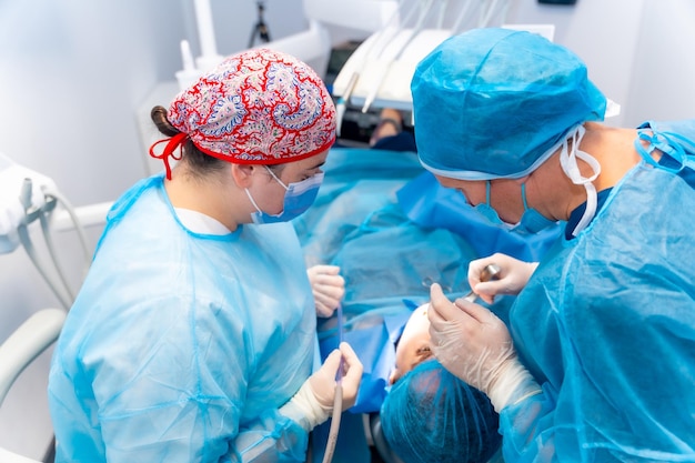 Médecin dentiste de la clinique dentaire avec l'assistant vérifiant la bouche du client avant l'opération