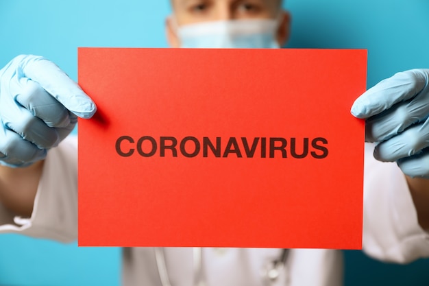 Médecin détient l'inscription Coronavirus sur bleu.